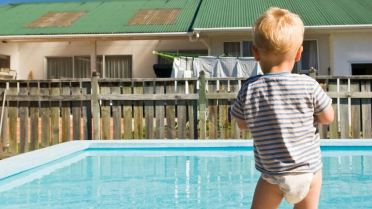 Little Boy in Diaper Looking at Backyard Pool