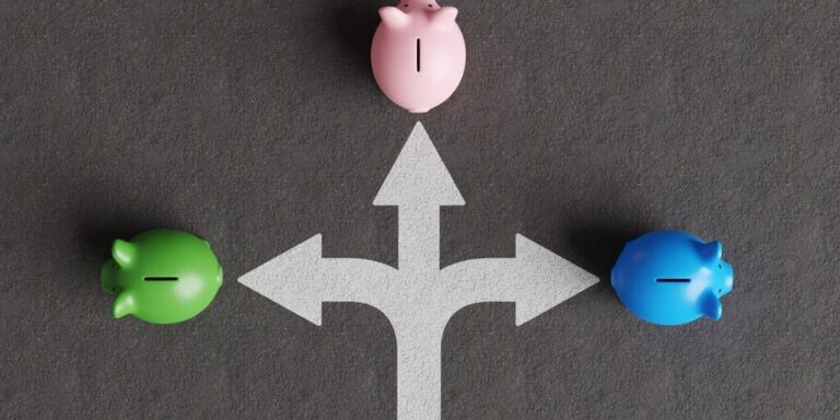 White divided road sign mark on asphalt with 3 different colored piggy banks going to different directions. gID 7